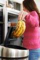 Frau wirft braune Bananen in den Mülleimer © panthermedia